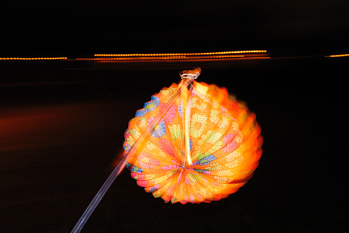 Lighting paper lantern in hand with illusion of motion and flame